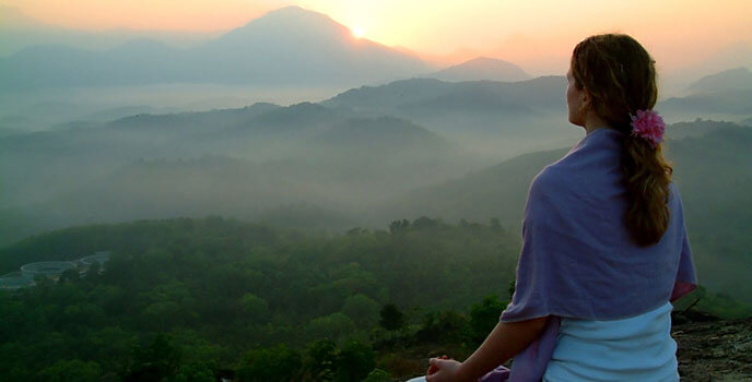 Frau bei Meditation im Sonnenuntergang